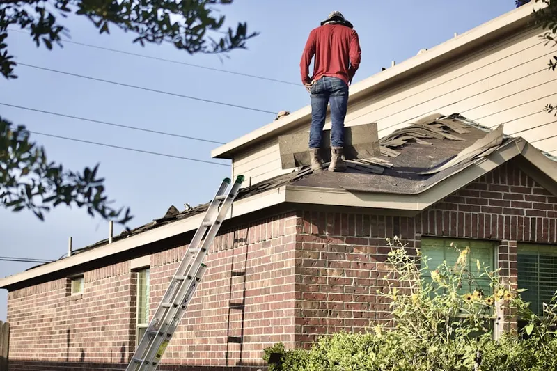 Professional roofer working on a residential roof in Village Green
